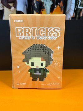 Мини-конструктор Танджиро Камадо Demon Slayer DMXC BRICKS F3041 в оранжевой коробке с изображением пиксельной фигурки в зелёно-чёрной одежде